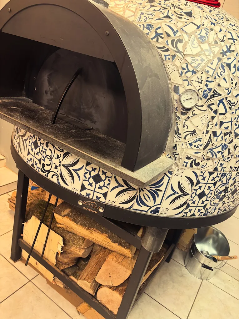 Le four à bois d'O'Mama, sa coupole recouverte d'une mosaïque d'azulejos bleus et blancs, le bois empilé sur l'étagère du dessous